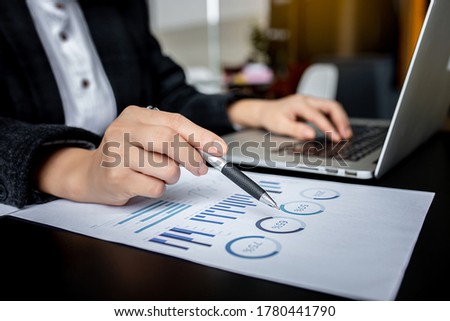 Business young woman checks charts and refreshes financial progress. The girl analyzes the business model in the workplace