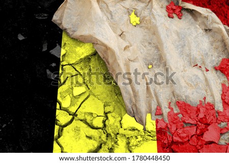 Belgium flag is pictured on cracked ground. The Concept of Ecology with Environmental Pollution from Domestic and Industrial Waste.