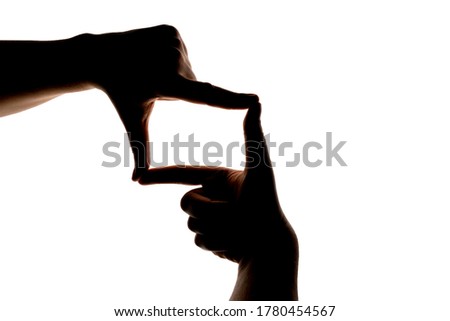Silhouette of hand showing photo frame gesture isolated on white background. Blank or mock-up for design.