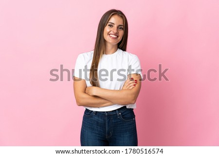 Young Uruguayan woman isolated on pink background keeping the arms crossed in frontal position