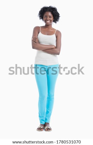 Portrait of confident young woman with arms crossed standing against white background