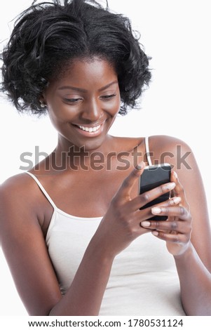 Happy young African American woman text messaging over white background