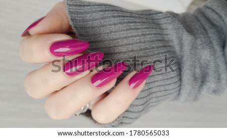 Woman's hands with long nails and pink fuchsia bottle manicure with nail polish Royalty-Free Stock Photo #1780565033