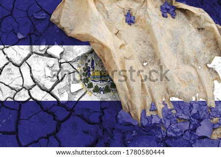 El Salvador flag is pictured on cracked ground. The Concept of Ecology with Environmental Pollution from Domestic and Industrial Waste.