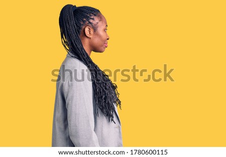 Young african american woman wearing business clothes looking to side, relax profile pose with natural face with confident smile. 