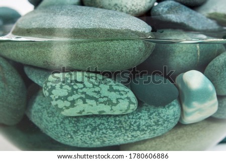 Turquoise sea pebbles in clear water close up