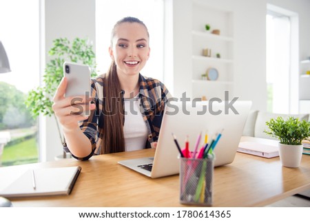 Photo of young pretty lady student browsing notebook sit table video call not listen teacher online conference cheating use telephone education concept social distance quarantine indoors