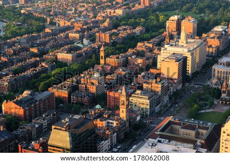 Boston city downtown aerial view with urban historical buildings at sunset.