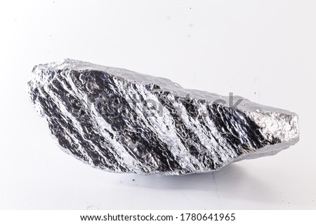Macro shot of nickel metal ore piece isolated on a white background. Closeup photo of surprising shiny rough mineral, chrome stone, used in industry Royalty-Free Stock Photo #1780641965