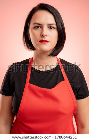 Woman employed at supermarket with red apron and black t-shirt, isolated on isolated on red background