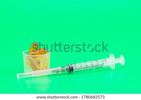 
A small syringe, coupled with the medicine in a small glass