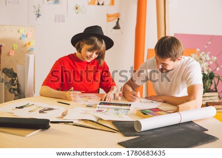 Young girl and guy artists designers create cartoons in studio. Photography for ad of art school or art blog