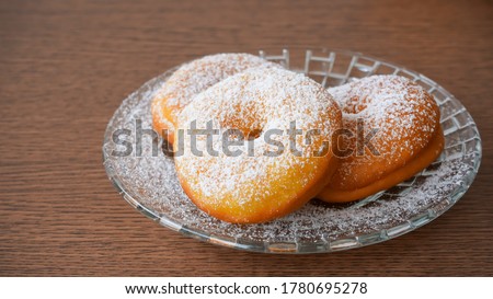 Donuts sprinkled with powdered sugar on a plate Royalty-Free Stock Photo #1780695278