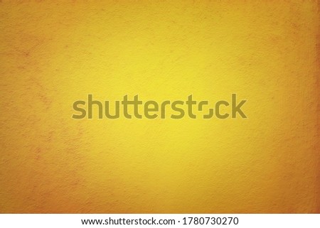 Orange colored abstract background with light glow and fine texture.