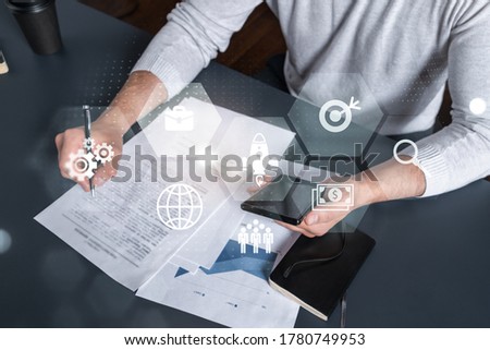 Double exposure of man signing contract with phone and business theme icon hologram. Concept of investment.