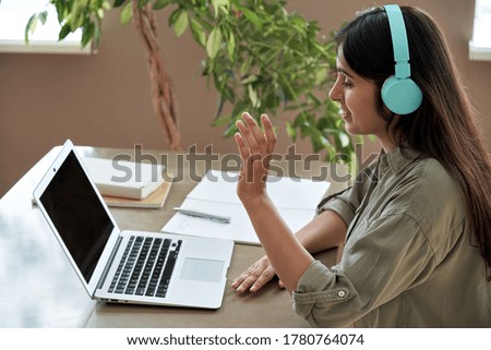 Happy indian teen girl student remote teacher tutor wear headphones giving online teaching class by webcam video call in lesson looking at laptop virtual conference meeting work at home office. Royalty-Free Stock Photo #1780764074