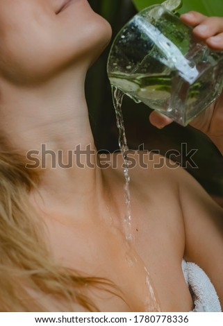 
A stream of clear water pours down the girl's neck.