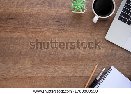 Top view above of wood office desk table with laptop, notebook and coffee cup with equipment other office supplies. Business and finance concept. Workplace, Flat lay with blank copy space.