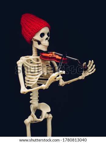 A skeleton in a red cap plays the violin.
