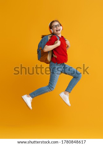 Back to school and happy time! Cute industrious child is jogging on color paper wall background. Kid with backpack. Girl ready to study. Royalty-Free Stock Photo #1780848617
