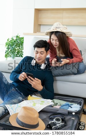 attractive asian couple happy people traveler searching information from mobile phone during backpack Luggage together at home before travel in holiday trip