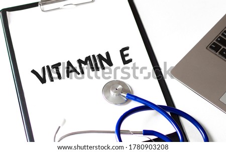 Paper plate, stethoscope and keyboard on the white background. VITAMIN E.