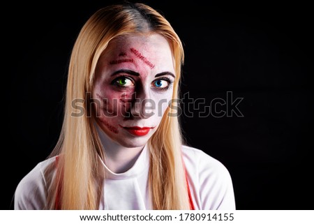 blond haired witch with green and blue eyes on a black background for Halloween. Toning. selective focus