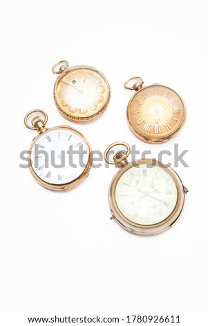 Four old-fashioned pocket watches over white background
