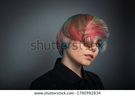 Portrait of nice young rainbow color fashion hair girl on grey background 