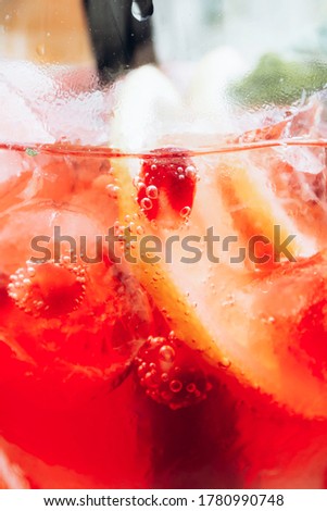 summer cocktail with mint, lemon slices and red berries
