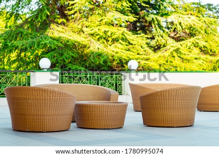 outdoor summer terrace, with stylish rattan furniture, in a cafe at sunset