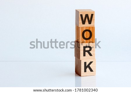 Text Work is written on wooden building blocks standing on a glass desk. Business concept.
