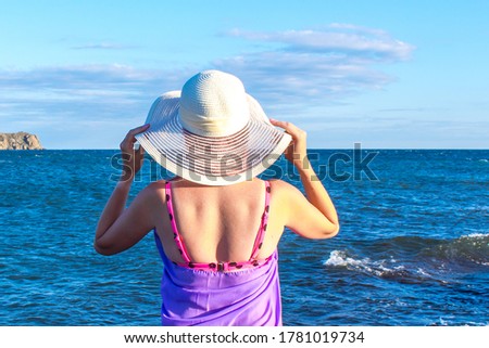 Girl in a hat on the beach by the sea