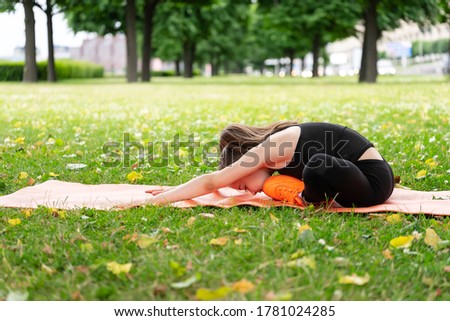 Gymnast schoolgirl warming up in a grass park before performing complex exercises. Series of photos