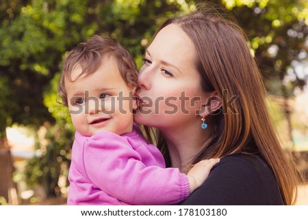 Happy mother and daughter are playing at a park, selective focus