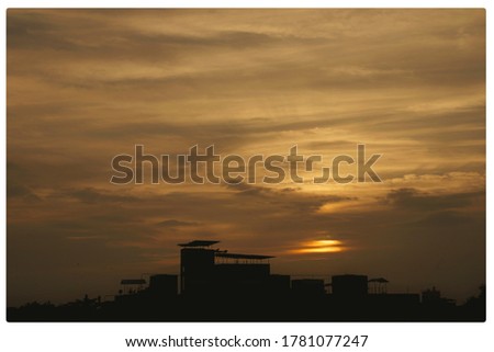 A beautiful sunset with a silhouette of a building  in the foreground 