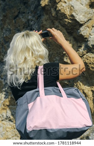 Female tourist taking photo with compact camera, enjoying mountains landscape