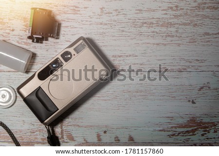 Close up retro or vintage film camera on rusty wooden table background with copy space.