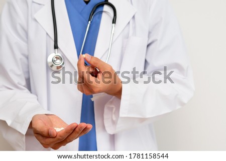 Male doctor in white coat with tablets