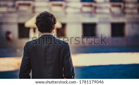 male portrait standing alone in the city. back view. Selective focus Royalty-Free Stock Photo #1781179046