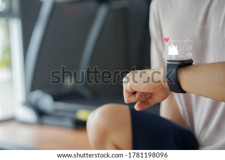  close up young man using smart watch to monitoring about healthcare tracker with virtual display to measure heart rate and calories while workout and rest for technology and futuristic life concept Royalty-Free Stock Photo #1781198096