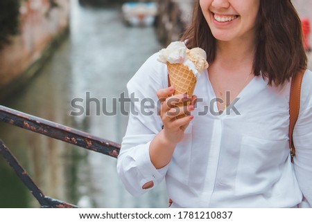 smiling woman with ice cream at city street