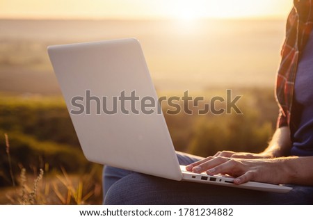 Girl working on her white computer on the top of the mountain. close up