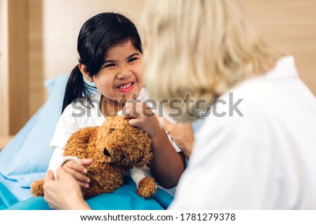 Woman doctor service help support discussing and consulting talk to little girl patient give teddy bear and check up information in hospital