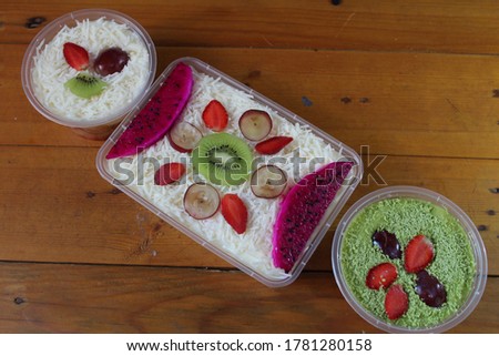 fruit salad of melon, grape, strawberry, kiwi dressed with natural yoghurt and sprinkled with chopped Apple