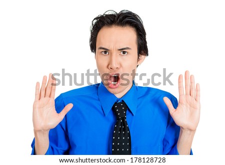 Closeup portrait of angry, mad young man raising hands up to say no, hold on, stop right there, isolated on white background. Negative emotion, facial expression feelings, signs symbols, body language