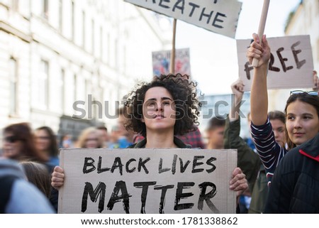 Black lives matters protesters holding signs and marching outdoors in streets.