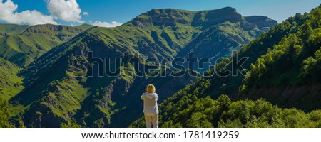 Woman take pictures from Forest, Elbrus Region at Summer. North Caucasus, Russia