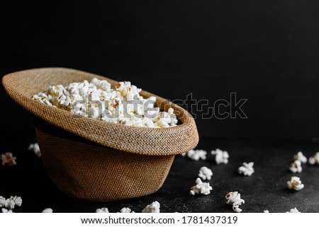 Salted popcorn in a straw hat