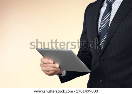 Attractive cheerful successful businessman holding in hands a digital tablet working